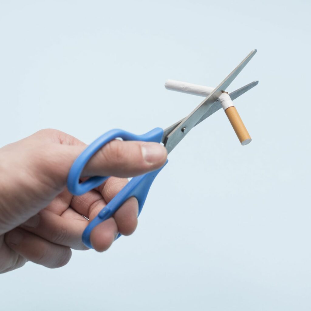 Cortar um cigarro como símbolo da cessação tabágica e decisão de parar de fumar